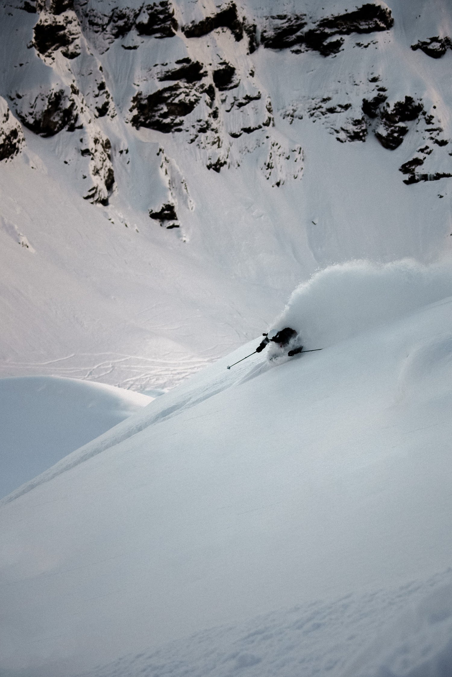 Skier making a turn through deep powder during a backcountry ski touring adventure.