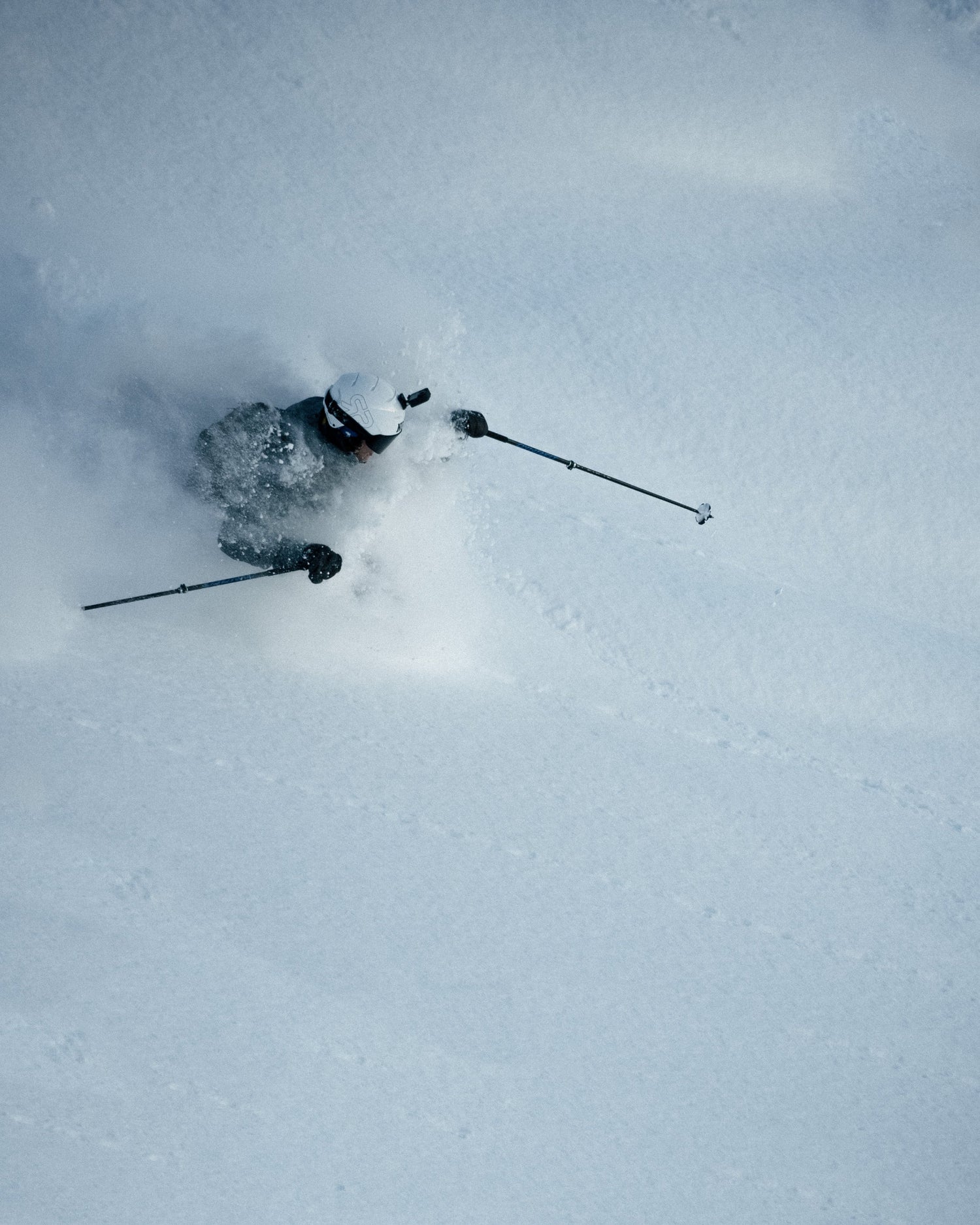 Skier using the Tjava Randi ski touring adapter while ascending in deep powder snow.