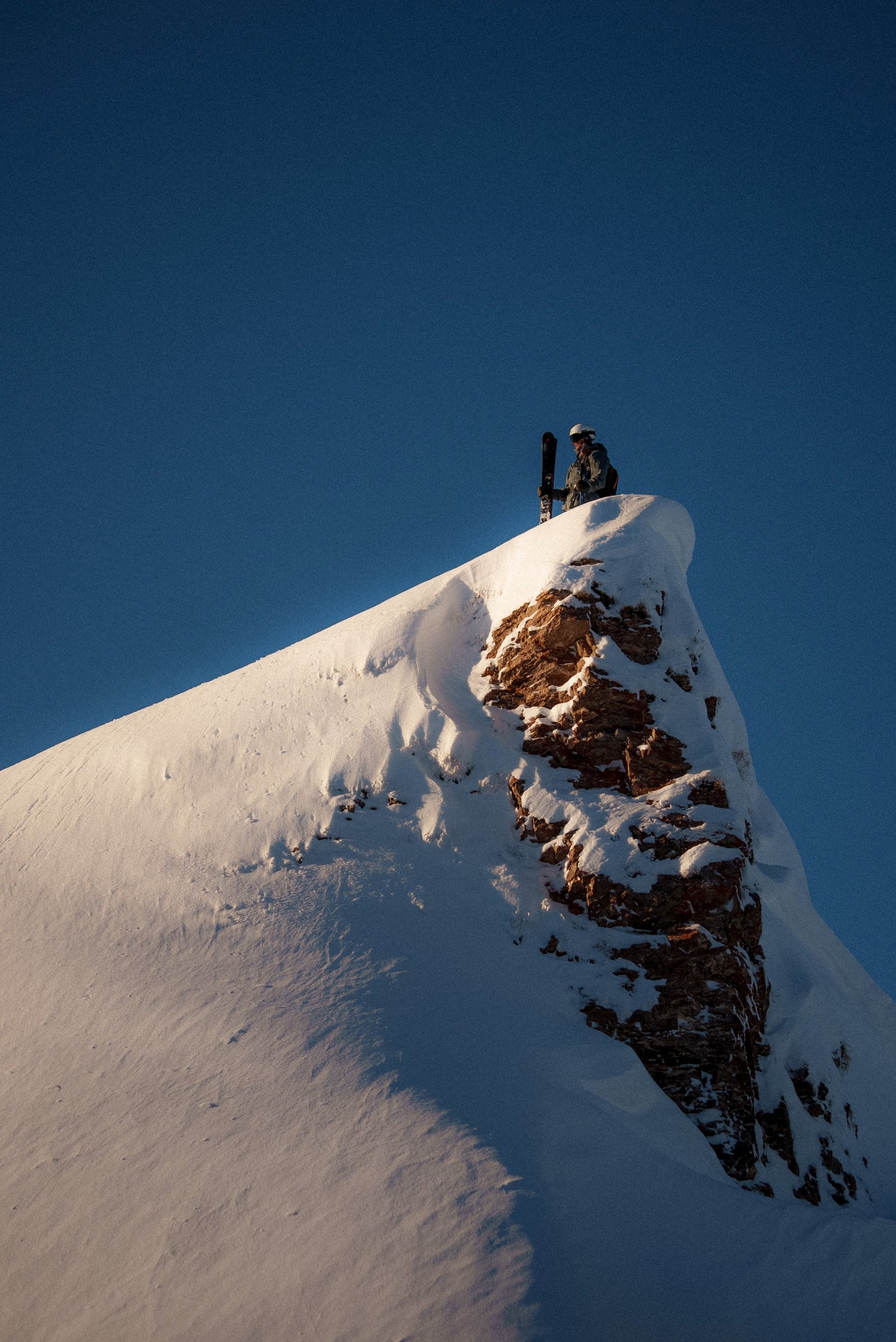 kier standing on a snowy mountain ridge during a ski touring adventure.